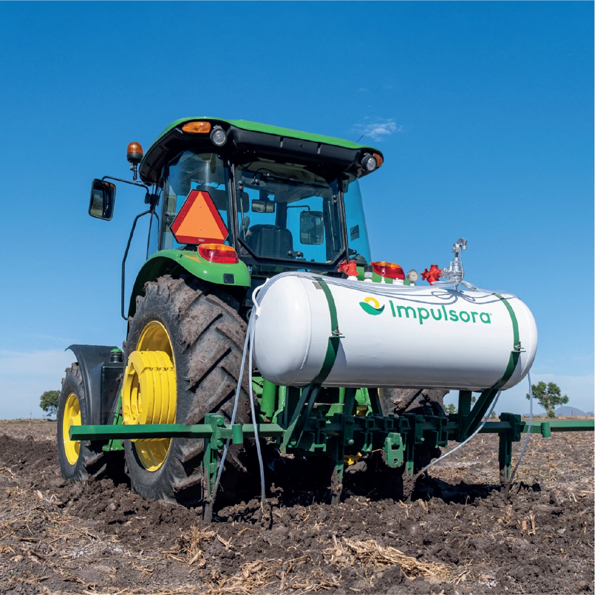 Tractor con tanque de Ammoniaboost, fertilizante nitrogenado Impulsora, aplicando en campo